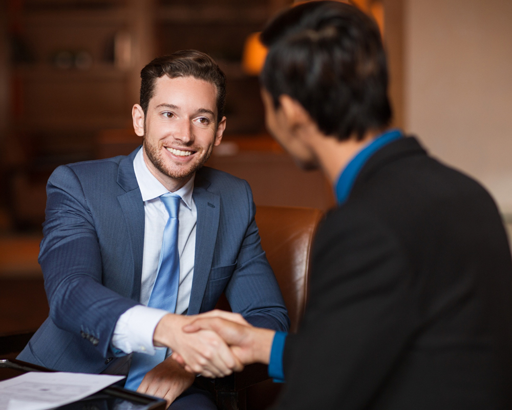 two-happy-partners-shaking-hands-cafe